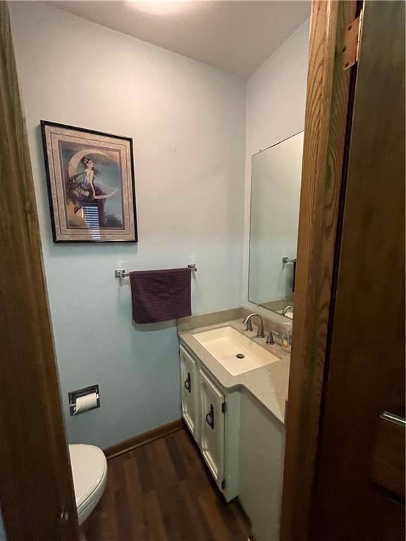1211 N 6th St, Hiawatha, KS 66434 - bathroom featuring vanity, wood finished floors, toilet, and baseboards