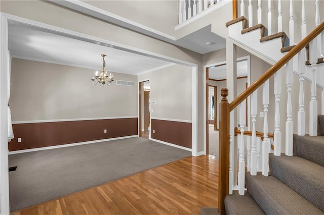 12726 S Rene St, Olathe, KS 66062 - entryway featuring wood finished floors, a chandelier, stairway, carpet, and baseboards