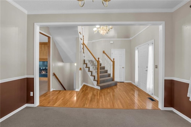 12726 S Rene St, Olathe, KS 66062 - carpeted foyer entrance featuring a chandelier, baseboards, wood finished floors, and ornamental molding