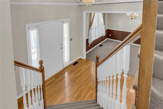 12726 S Rene St, Olathe, KS 66062 - foyer entrance featuring a chandelier, stairs, wood finished floors, baseboards, and ornamental molding