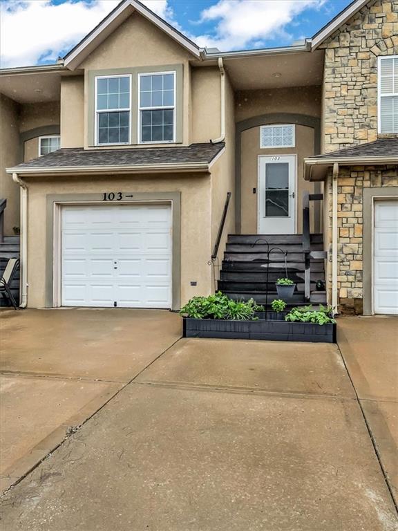 1151 N Mart-Way Dr Unit 103, Olathe, KS 66061 - view of front of home with stucco siding, concrete driveway, stone siding, and an attached garage