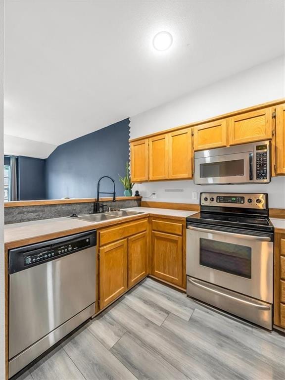 1151 N Mart-Way Dr Unit 103, Olathe, KS 66061 - kitchen with stainless steel appliances, a sink, light wood-type flooring, light countertops, and brown cabinetry