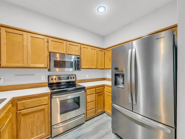 1151 N Mart-Way Dr Unit 103, Olathe, KS 66061 - kitchen featuring stainless steel appliances, light countertops, and light wood-type flooring