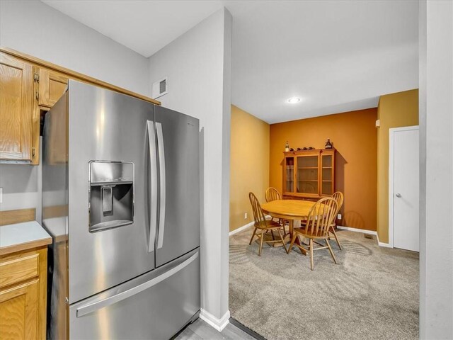 1151 N Mart-Way Dr Unit 103, Olathe, KS 66061 - kitchen featuring stainless steel refrigerator with ice dispenser, baseboards, light colored carpet, and light countertops