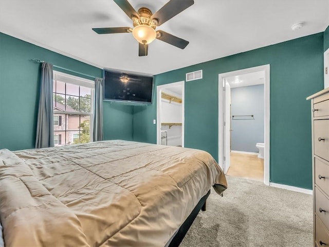 1151 N Mart-Way Dr Unit 103, Olathe, KS 66061 - bedroom featuring carpet, baseboards, connected bathroom, ceiling fan, and a walk in closet