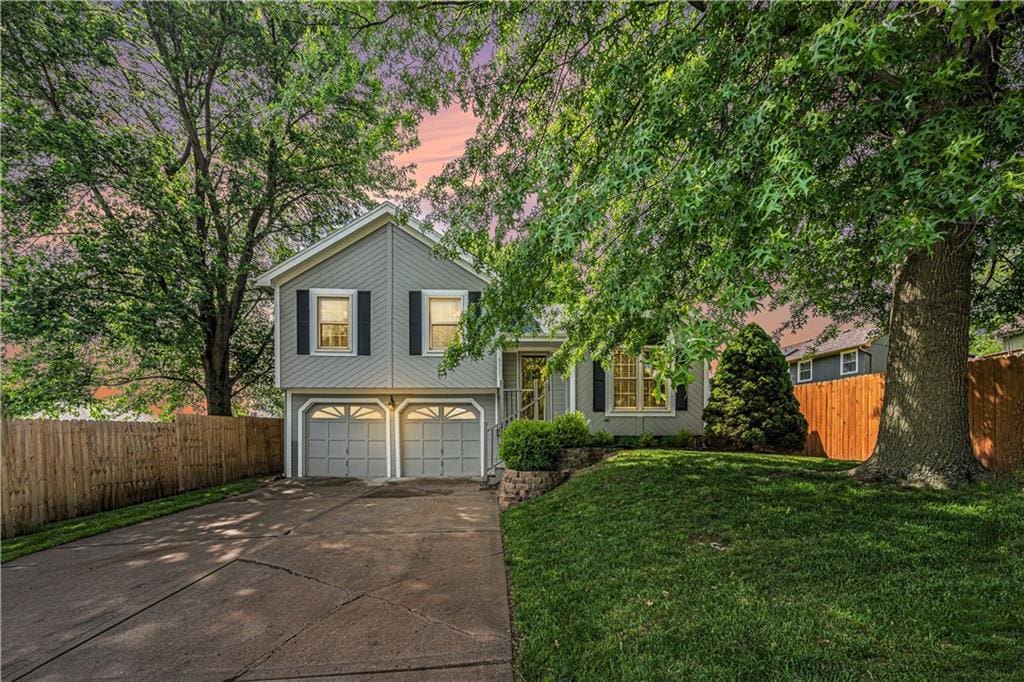 8311 NE 112th St, Kansas City, MO 64157 - split level home featuring concrete driveway and an attached garage