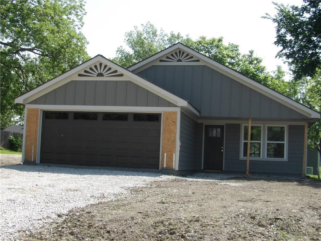 303 S Lexington St, Holden, MO 64061 - ranch-style house featuring a garage and board and batten siding