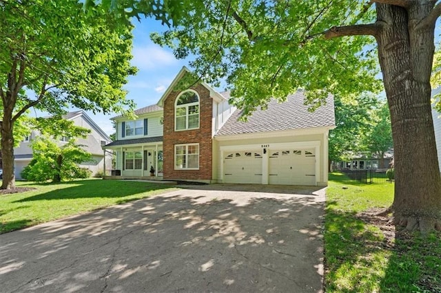 8443 Mettee St, Lenexa, KS 66219 - traditional-style home featuring driveway, a front lawn, a garage, and brick siding