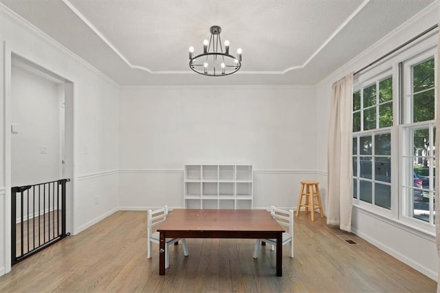 8443 Mettee St, Lenexa, KS 66219 - unfurnished dining area with a raised ceiling, wood finished floors, a chandelier, ornamental molding, and baseboards