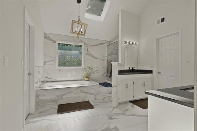 8443 Mettee St, Lenexa, KS 66219 - full bathroom with vanity, marble tiled floors, a chandelier, a garden tub, and a marble finish shower