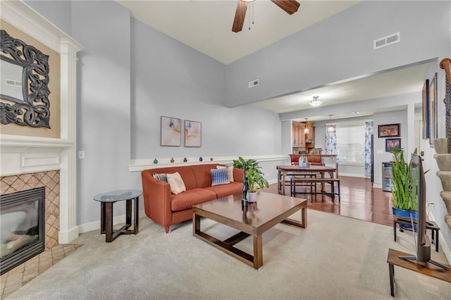 15828 W 61st St, Shawnee, KS 66217 - living area with a high ceiling, ceiling fan, a tiled fireplace, carpet, and baseboards