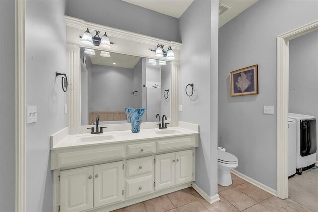 15828 W 61st St, Shawnee, KS 66217 - bathroom featuring washer and clothes dryer, double vanity, toilet, tile patterned flooring, and baseboards