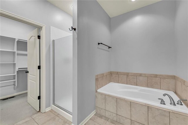 15828 W 61st St, Shawnee, KS 66217 - bathroom with a spacious closet, a garden tub, a shower stall, tile patterned floors, and baseboards