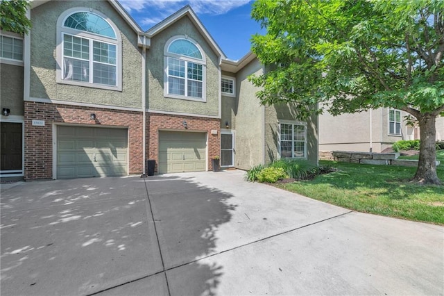 15828 W 61st St, Shawnee, KS 66217 - multi unit property featuring driveway, an attached garage, stucco siding, a front lawn, and brick siding