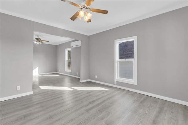 311 N Silver St, Paola, KS 66071 - empty room featuring a wall mounted AC, ceiling fan, baseboards, wood finished floors, and ornamental molding