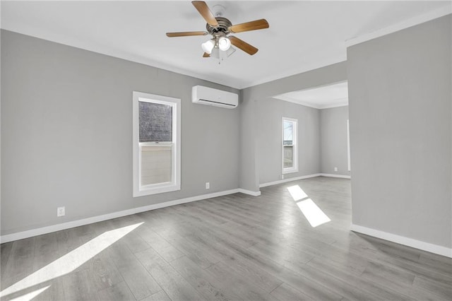 311 N Silver St, Paola, KS 66071 - empty room featuring an AC wall unit, wood finished floors, baseboards, ceiling fan, and crown molding