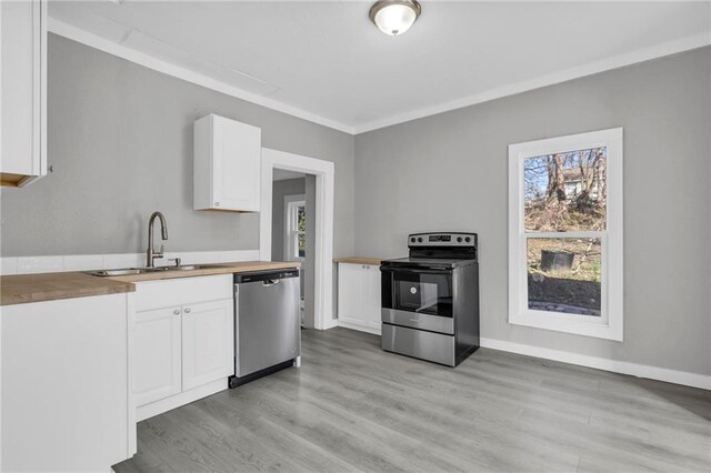 311 N Silver St, Paola, KS 66071 - kitchen with appliances with stainless steel finishes, wood counters, a sink, white cabinetry, and light wood finished floors