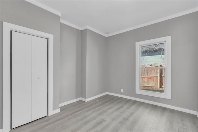 311 N Silver St, Paola, KS 66071 - unfurnished bedroom with crown molding, wood finished floors, baseboards, and a closet