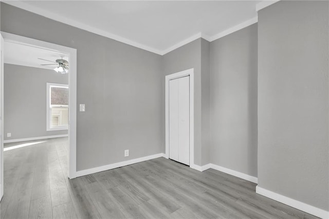 311 N Silver St, Paola, KS 66071 - empty room with wood finished floors, a ceiling fan, baseboards, and ornamental molding