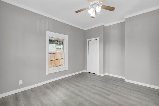311 N Silver St, Paola, KS 66071 - spare room with crown molding, baseboards, a ceiling fan, and wood finished floors