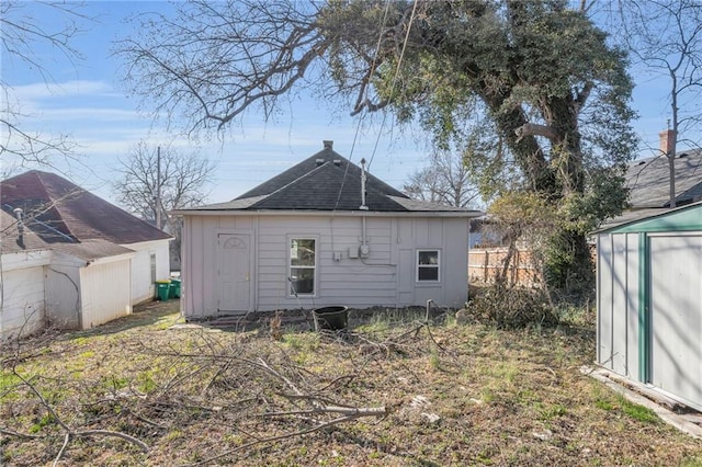 311 N Silver St, Paola, KS 66071 - rear view of property with board and batten siding and roof with shingles