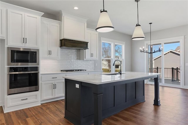 12425 NW Empress St, Platte City, MO 64079 - kitchen featuring stainless steel oven, a sink, built in microwave, a chandelier, and dark wood-type flooring