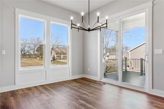 12425 NW Empress St, Platte City, MO 64079 - unfurnished dining area with a chandelier, wood finished floors, and healthy amount of natural light