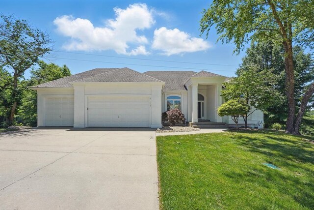 165 NE Hidden Ridge Ln, Lees Summit, MO 64064 - ranch-style home featuring a front yard, driveway, roof with shingles, a garage, and stucco siding