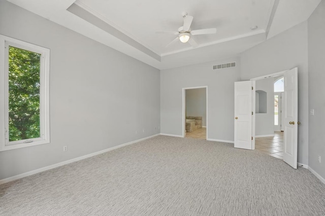 165 NE Hidden Ridge Ln, Lees Summit, MO 64064 - unfurnished bedroom featuring a raised ceiling, multiple windows, light colored carpet, and ornamental molding
