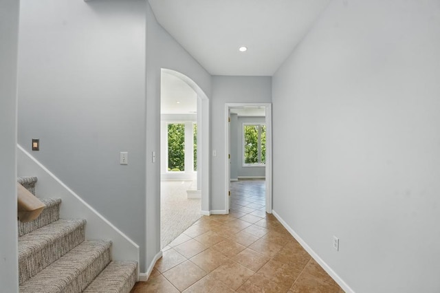 165 NE Hidden Ridge Ln, Lees Summit, MO 64064 - corridor with arched walkways, baseboards, recessed lighting, light tile patterned floors, and stairway