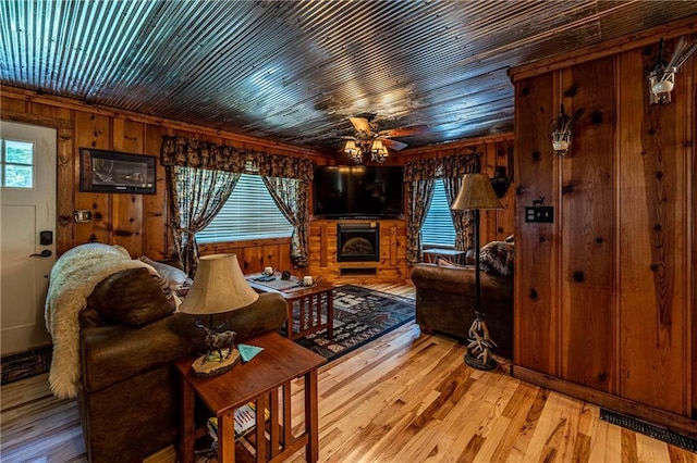 26406 Waterview Dr, Warsaw, MO 65355 - living room with a ceiling fan, wooden walls, a fireplace, and light wood-type flooring