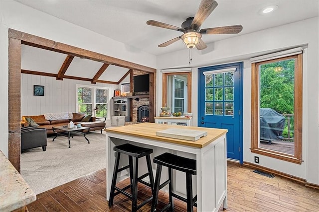 14613 S Locust St, Olathe, KS 66062 - kitchen featuring butcher block counters, wood finished floors, healthy amount of natural light, ceiling fan, and vaulted ceiling