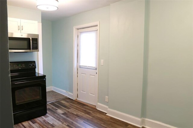 816 S Huttig Ave, Independence, MO 64053 - kitchen featuring stainless steel microwave, black electric range, baseboards, and dark wood finished floors