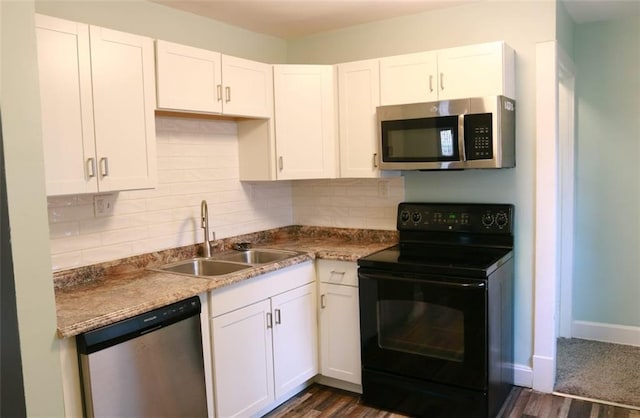 816 S Huttig Ave, Independence, MO 64053 - kitchen with appliances with stainless steel finishes, a sink, white cabinetry, and decorative backsplash