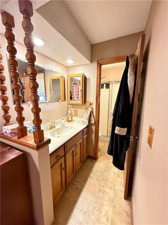 450 SW 725th Rd, Chilhowee, MO 64733 - bathroom featuring a textured ceiling, vanity, and tile patterned flooring