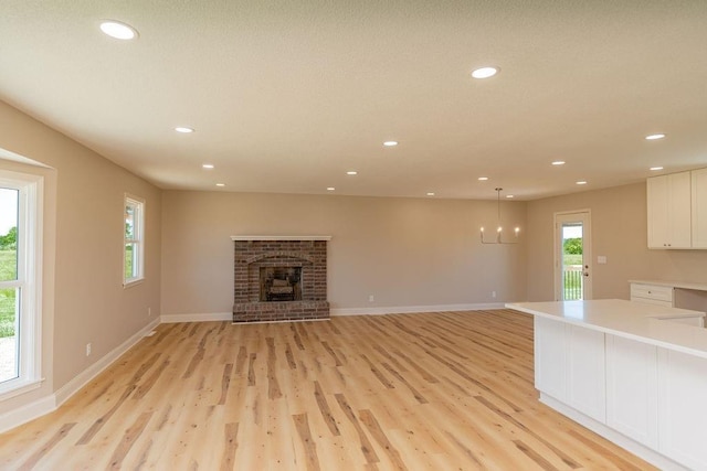 22102 E 291st St, Harrisonville, MO 64701 - unfurnished living room featuring light wood-style floors, recessed lighting, a fireplace, and baseboards