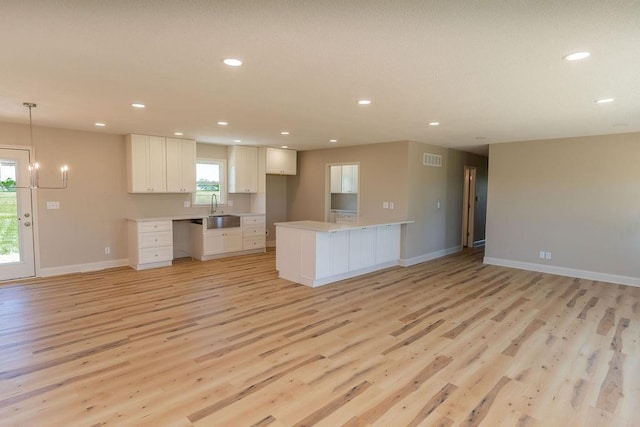 22102 E 291st St, Harrisonville, MO 64701 - kitchen with light wood-type flooring, white cabinetry, light countertops, a sink, and recessed lighting