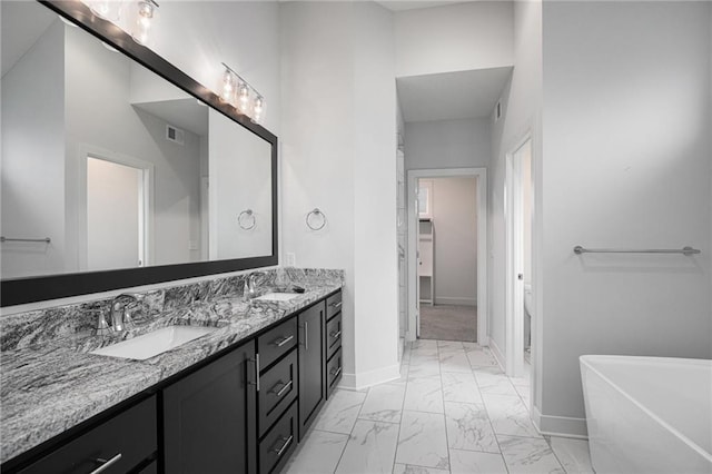 8316 NW 90th St, Kansas City, MO 64153 - bathroom featuring marble finish floors, double vanity, a soaking tub, and baseboards