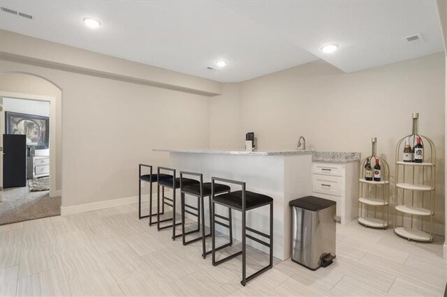 8605 NE Shl Creek Pkwy, Kansas City, MO 64157 - bar area featuring arched walkways, baseboards, recessed lighting, and a sink