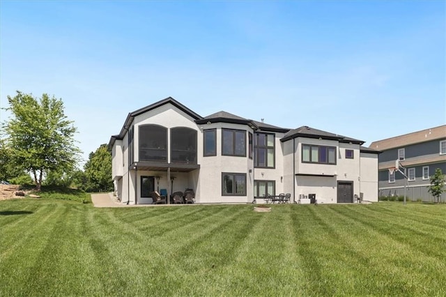 8605 NE Shl Creek Pkwy, Kansas City, MO 64157 - back of house featuring stucco siding, a sunroom, and a yard