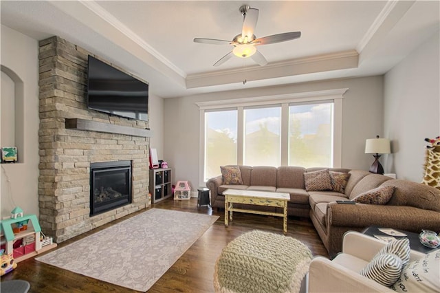 25383 W 144th Ct, Olathe, KS 66061 - living area with a raised ceiling, crown molding, a large fireplace, dark wood-type flooring, and a ceiling fan