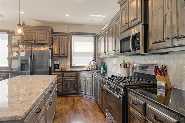 25383 W 144th Ct, Olathe, KS 66061 - kitchen with appliances with stainless steel finishes, a sink, dark wood-type flooring, tasteful backsplash, and light stone counters
