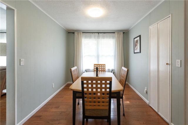 8401 England St, Overland Park, KS 66212 - dining room with wood finished floors, crown molding, baseboards, and a textured ceiling