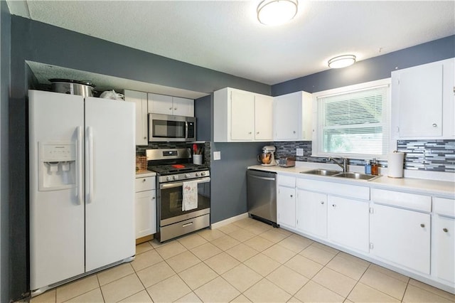 8401 England St, Overland Park, KS 66212 - kitchen with appliances with stainless steel finishes, a sink, decorative backsplash, and white cabinetry