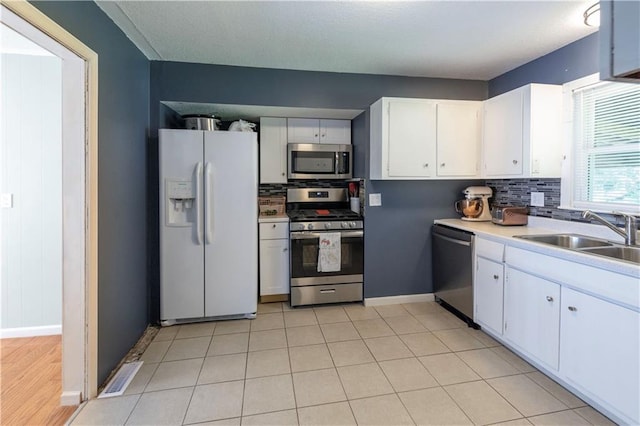 8401 England St, Overland Park, KS 66212 - kitchen with stainless steel appliances, a sink, white cabinets, and baseboards