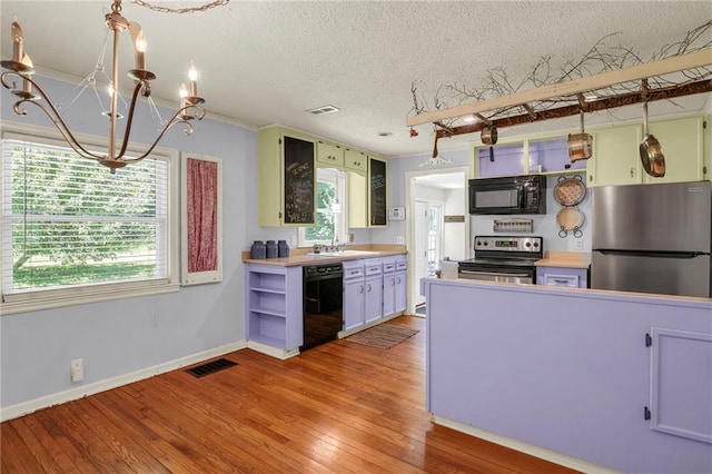 10916 Grandview Rd, Kansas City, MO 64137 - kitchen with black appliances, a chandelier, a sink, a textured ceiling, and plenty of natural light