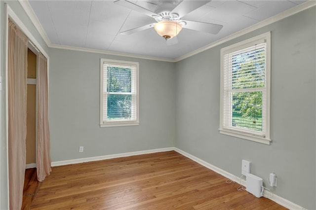 10916 Grandview Rd, Kansas City, MO 64137 - unfurnished bedroom with multiple windows, ornamental molding, light wood-type flooring, baseboards, and a closet