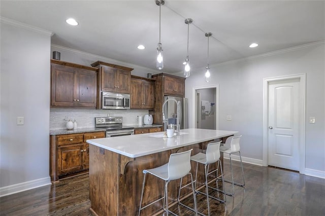 1644 Woodland Shores Cir, Lees Summit, MO 64086 - kitchen featuring appliances with stainless steel finishes, ornamental molding, baseboards, a breakfast bar area, and a kitchen island with sink