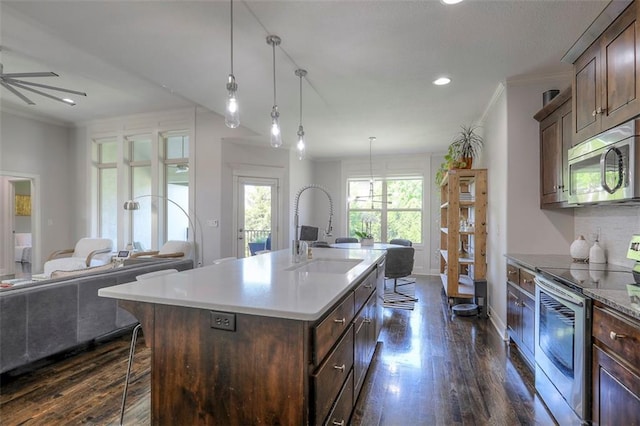 1644 Woodland Shores Cir, Lees Summit, MO 64086 - kitchen featuring appliances with stainless steel finishes, a sink, open floor plan, dark wood-style floors, and crown molding