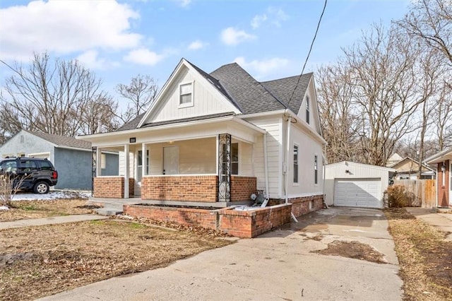 1514 N 25th St, Kansas City, KS 66102 - view of front of home with brick siding, a porch, an outbuilding, concrete driveway, and a detached garage